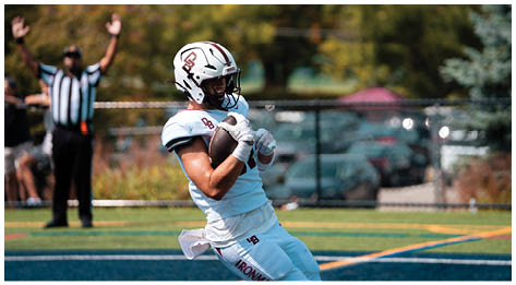 A football player wearing a blue and red jersey. Description generated by AI
