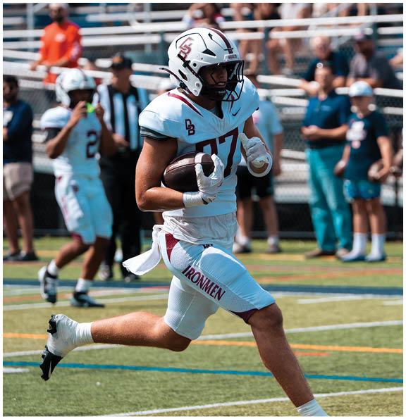 A football player wearing a blue and red jersey. Description generated by AI