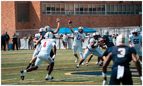 A football player wearing a blue and red jersey. Description generated by AI