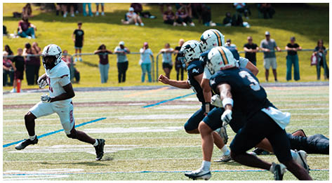 A football player wearing a blue and red jersey. Description generated by AI