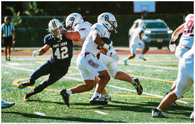 A football player wearing a blue and red jersey. Description generated by AI