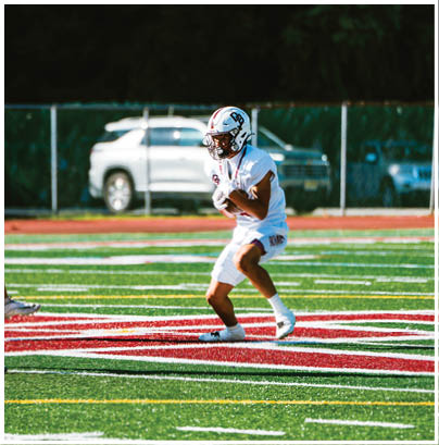 A football player wearing a blue and red jersey. Description generated by AI