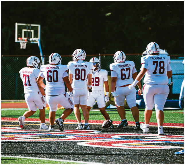 A football player wearing a blue and red jersey. Description generated by AI