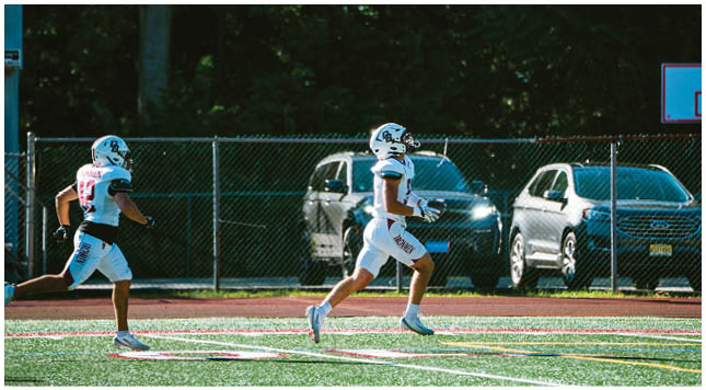 A football player wearing a blue and red jersey. Description generated by AI