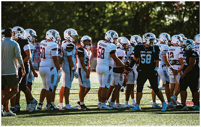 A football player wearing a blue and red jersey. Description generated by AI