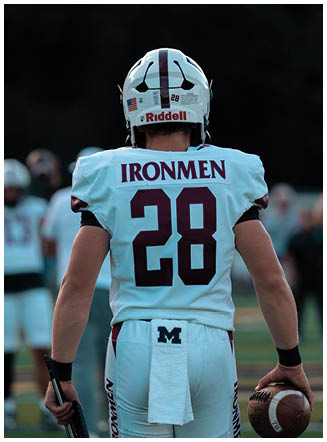 A football player wearing a blue and red jersey. Description generated by AI