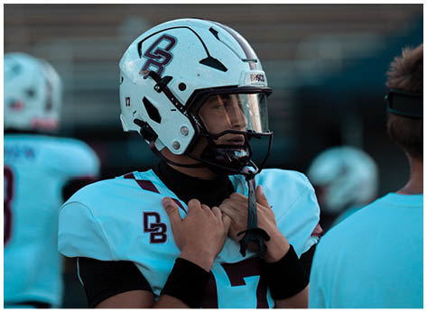A football player wearing a blue and red jersey. Description generated by AI