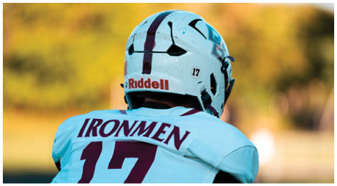 A football player wearing a blue and red jersey. Description generated by AI