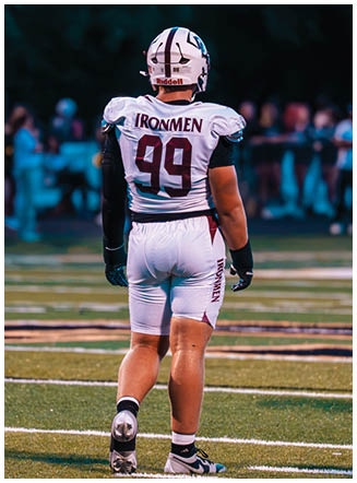 A football player wearing a blue and red jersey. Description generated by AI