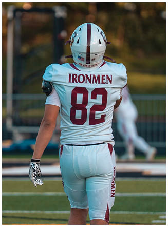 A football player wearing a blue and red jersey. Description generated by AI