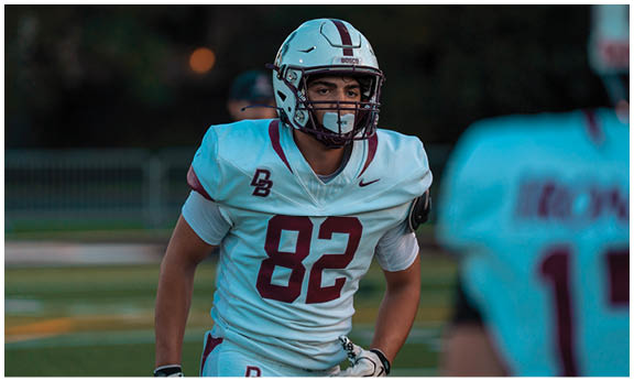 A football player wearing a blue and red jersey. Description generated by AI