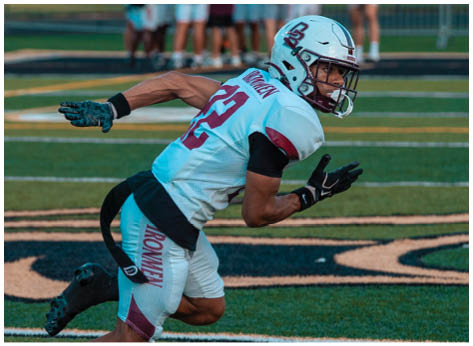 A football player wearing a blue and red jersey. Description generated by AI
