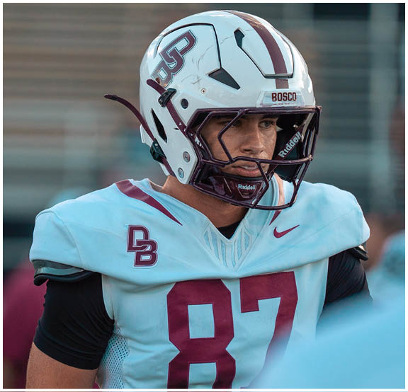 A football player wearing a blue and red jersey. Description generated by AI