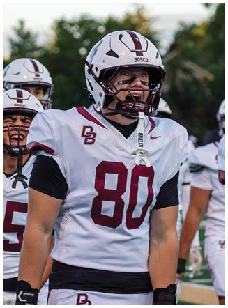 A football player wearing a blue and red jersey. Description generated by AI