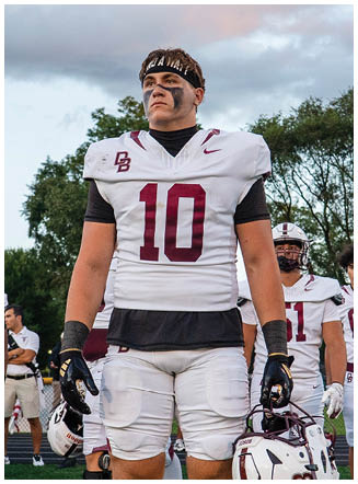 A football player wearing a blue and red jersey. Description generated by AI
