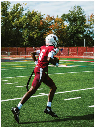 A football player wearing a blue and red jersey. Description generated by AI