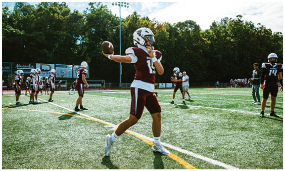 A football player wearing a blue and red jersey. Description generated by AI