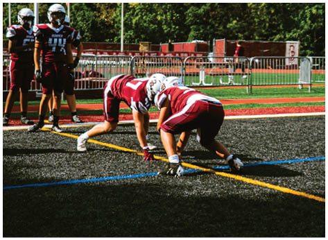 A football player wearing a blue and red jersey. Description generated by AI