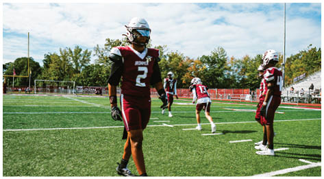 A football player wearing a blue and red jersey. Description generated by AI