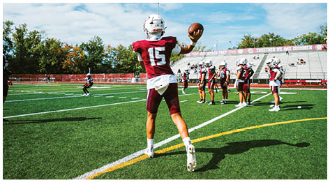 A football player wearing a blue and red jersey. Description generated by AI