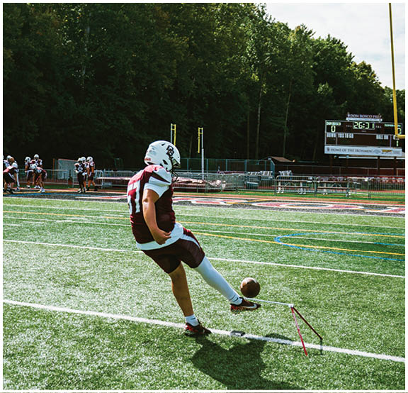 A football player wearing a blue and red jersey. Description generated by AI