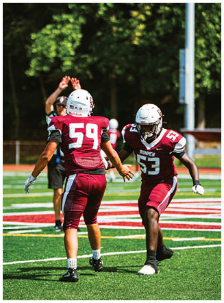 A football player wearing a blue and red jersey. Description generated by AI