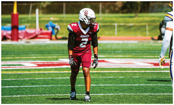 A football player wearing a blue and red jersey. Description generated by AI