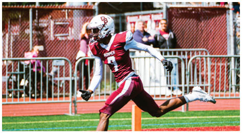 A football player wearing a blue and red jersey. Description generated by AI