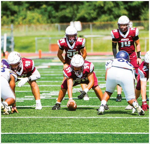 A football player wearing a blue and red jersey. Description generated by AI