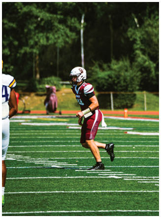 A football player wearing a blue and red jersey. Description generated by AI