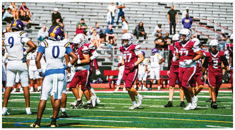 A football player wearing a blue and red jersey. Description generated by AI