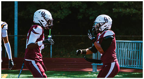 A football player wearing a blue and red jersey. Description generated by AI