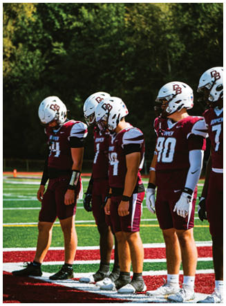 A football player wearing a blue and red jersey. Description generated by AI