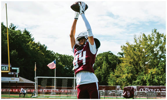 A football player wearing a blue and red jersey. Description generated by AI
