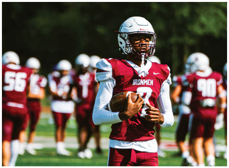 A football player wearing a blue and red jersey. Description generated by AI