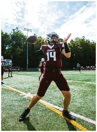 A football player wearing a blue and red jersey. Description generated by AI