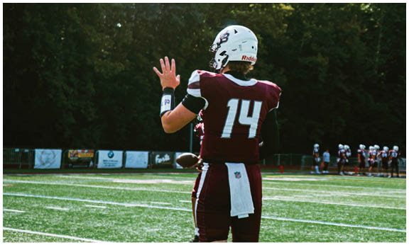 A football player wearing a blue and red jersey. Description generated by AI