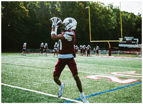 A football player wearing a blue and red jersey. Description generated by AI