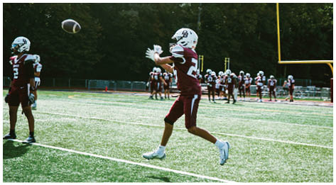 A football player wearing a blue and red jersey. Description generated by AI