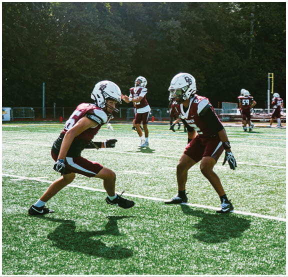 A football player wearing a blue and red jersey. Description generated by AI