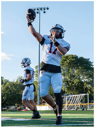 A football player wearing a blue and red jersey. Description generated by AI