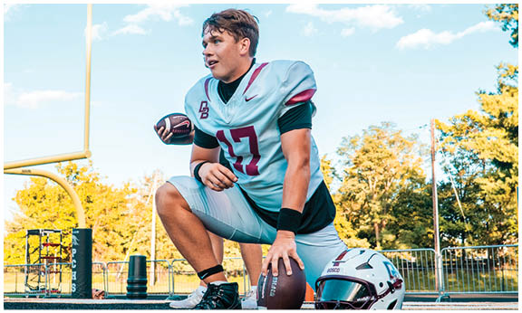 A football player wearing a blue and red jersey. Description generated by AI