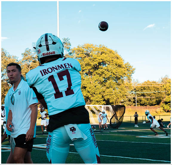 A football player wearing a blue and red jersey. Description generated by AI