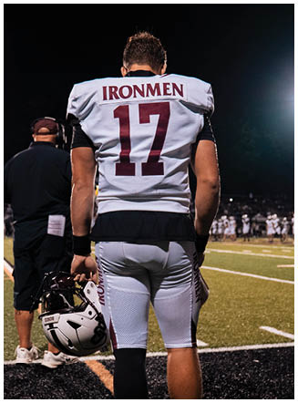 A football player wearing a blue and red jersey. Description generated by AI