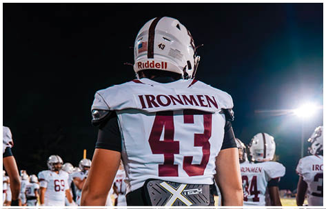 A football player wearing a blue and red jersey. Description generated by AI