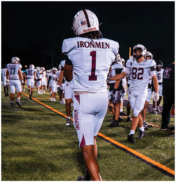 A football player wearing a blue and red jersey. Description generated by AI