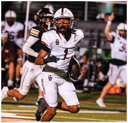 A football player running on the field. Description generated by AI