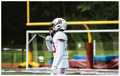 A football player wearing a blue and red jersey. Description generated by AI