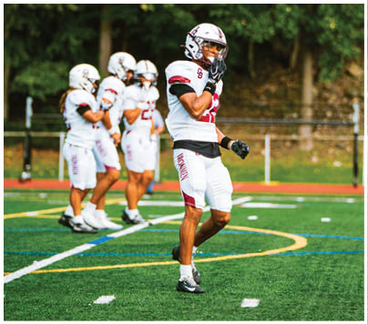 A football player wearing a blue and red jersey. Description generated by AI