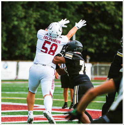 A football player wearing a blue and red jersey. Description generated by AI